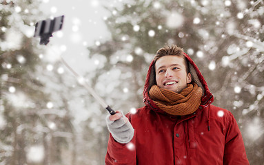 Image showing happy man taking selfie by smartphone in winter