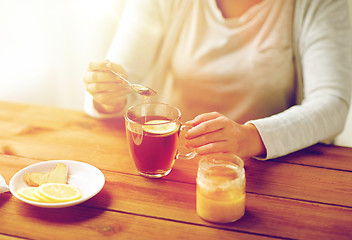 Image showing close up of ill woman drinking tea with lemon