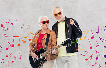 Image showing senior couple in sunglasses with electric guitar