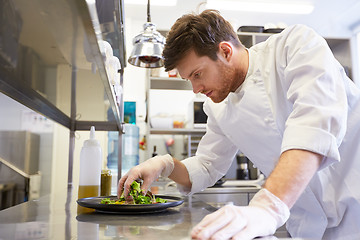 Image showing happy male chef cooking food at restaurant kitchen