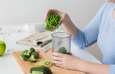Image showing woman hand adding pea to measuring cup