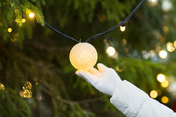 Image showing close up of hand with christmas tree garland bulb