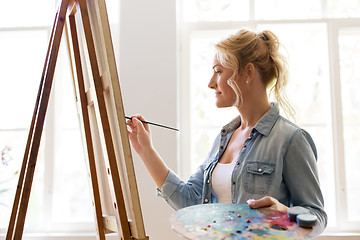 Image showing woman artist with easel painting at art studio