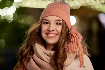 Image showing happy young woman over christmas lights in winter