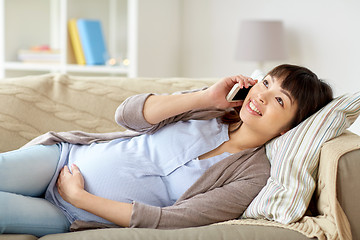 Image showing happy pregnant woman calling on smartphone at home