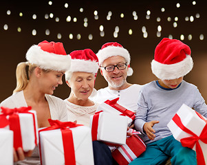 Image showing happy family in santa hats with christmas gifts
