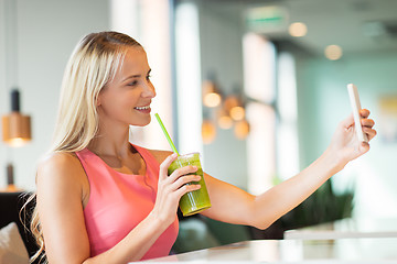 Image showing woman with smartphone taking selfie at restaurant