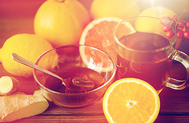 Image showing tea with honey, lemon and ginger on wood