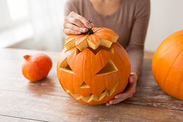 Image showing close up of woman with halloween pumpkin at home