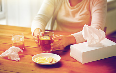 Image showing close up of ill woman drinking tea with lemon