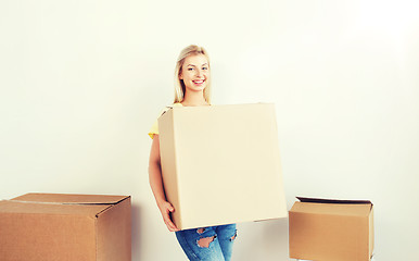 Image showing smiling young woman with cardboard box at home