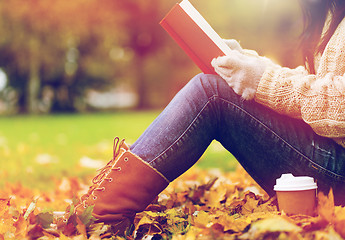 Image showing woman with book drinking coffee in autumn park