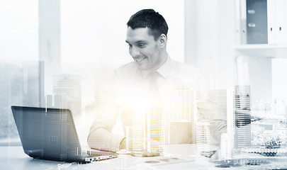 Image showing smiling businessman with laptop and documents