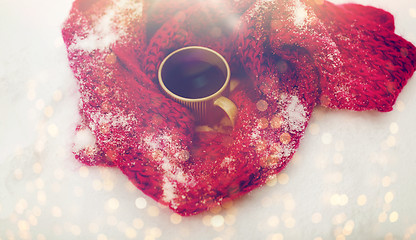 Image showing tea or coffee mug and winter scarf on snow