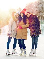 Image showing happy young women with smartphone on skating rink