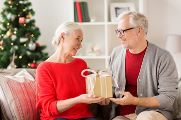 Image showing happy smiling senior couple with christmas gift