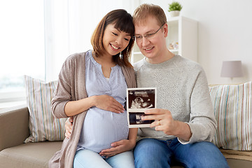 Image showing happy couple with ultrasound images at home