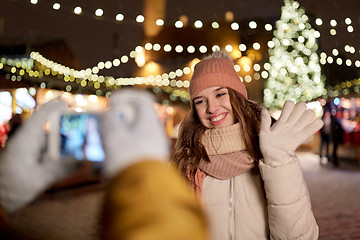 Image showing happy woman posing for smartphone at christmas