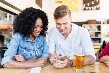 Image showing happy man and woman with smartphone at bar