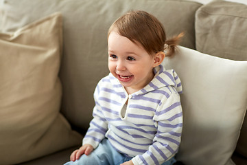 Image showing happy smiling baby girl sitting on sofa at home