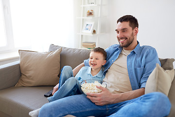 Image showing father and son with popcorn watching tv at home