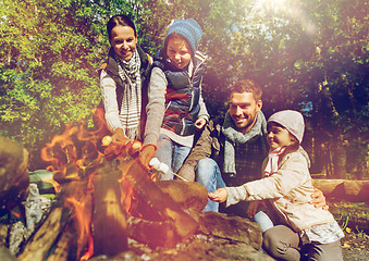 Image showing happy family roasting marshmallow over campfire