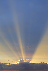 Image showing Vertical sky with sun rays bursting forth from behind clouds edg