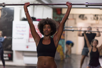 Image showing black woman lifting empty bar