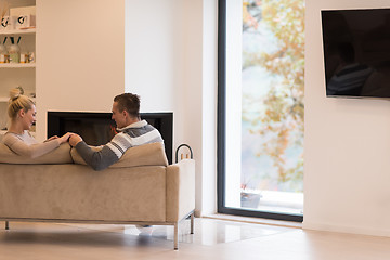 Image showing Young couple  in front of fireplace