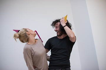 Image showing couple in party hats blowing in whistle