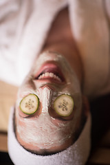 Image showing woman is getting facial clay mask at spa