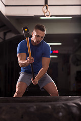 Image showing man workout with hammer and tractor tire