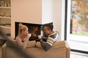 Image showing Young couple  in front of fireplace