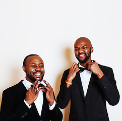 Image showing two afro-american businessmen in black suits emotional posing, gesturing, smiling. wearing bow-ties 