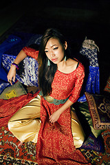 Image showing young pretty asian girl in bright colored interior on carpet