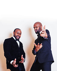 Image showing two afro-american businessmen in black suits emotional posing, gesturing, smiling. wearing bow-ties 