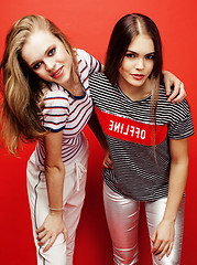 Image showing two best friends teenage girls together having fun, posing emotional on red background, besties happy smiling, lifestyle people concept 