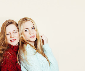 Image showing Two young girlfriends in winter sweaters indoors having fun. Lif