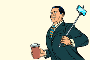 Image showing Asian businessman with a selfie stick and coffee