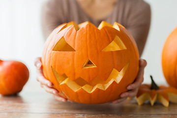 Image showing close up of woman with halloween pumpkin at home