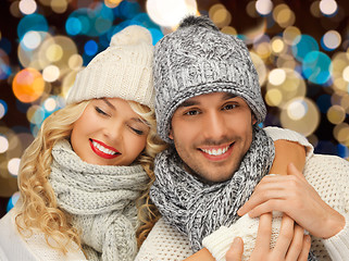 Image showing happy couple in hats over lights background