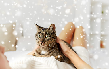 Image showing young woman with cat lying in bed at home