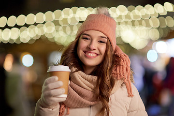 Image showing happy woman with coffee over christmas lights