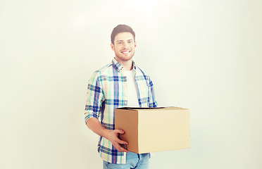 Image showing smiling young man with cardboard box at home