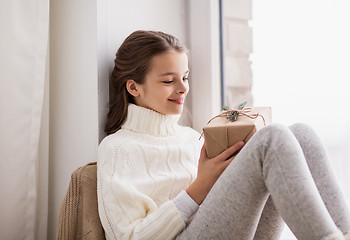 Image showing girl with christmas gift sitting at home