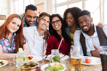 Image showing happy friends eating at restaurant