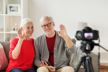 Image showing happy senior couple with camera recording video