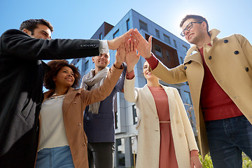 Image showing group of happy people making high five in city