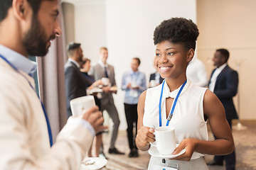 Image showing business people with conference badges and coffee