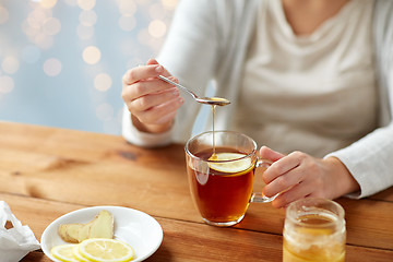 Image showing close up of ill woman drinking tea with lemon